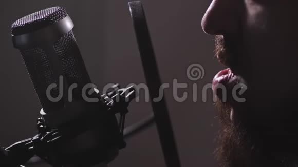 录音室特写镜头留胡子的人唱一首歌或把课文读入麦克风4K慢慢视频的预览图