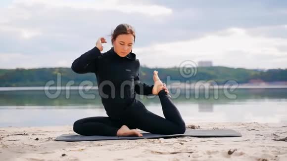 河岸上的一个女孩正在练瑜伽视频的预览图