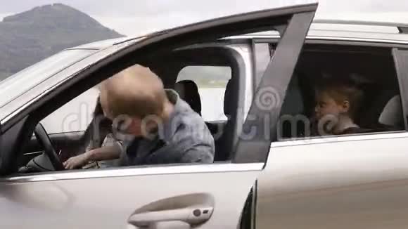 母亲父亲儿子和小猎犬坐在车里系好安全带出发去旅行视频的预览图