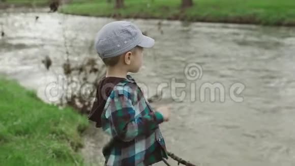 小男孩看着公园里的湖视频的预览图