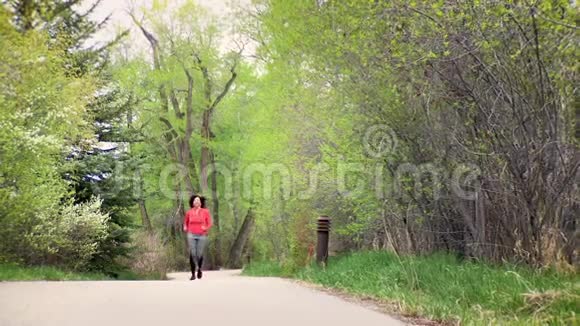 漂亮的非裔美国女人在公园或树林里跑步和锻炼视频的预览图