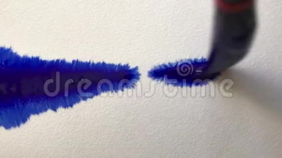 美丽的水彩蓝色墨水滴在白纸上艺术家用画笔作画在纸上写一行字视频的预览图