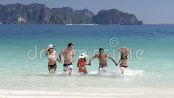 美丽的海滩上欢乐的人从水中奔跑男男女女的朋友在海上度假视频的预览图