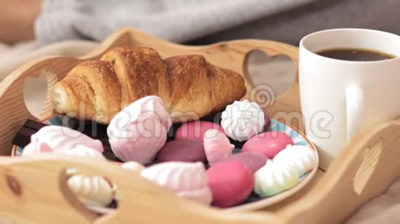 美丽的女孩在早餐时用棉花糖在床上缓慢地喂她的男朋友视频的预览图