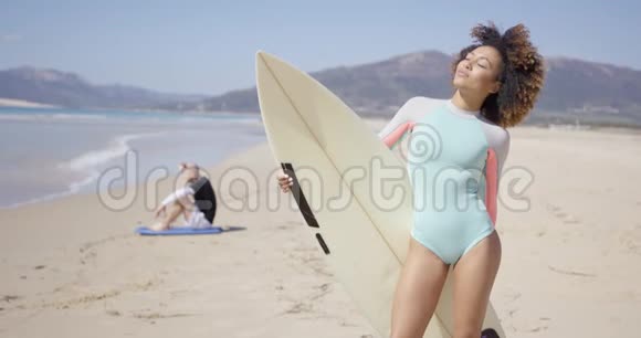 在海滩上摆着冲浪板的女性视频的预览图