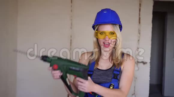 年轻性感的女建筑工用电动工具一个建筑女工的肖像视频的预览图