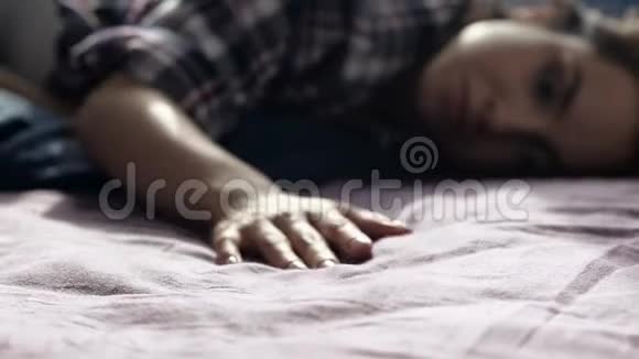 隔离期间年轻女子呆在家里平静安详的女人躺在床上拿些亚麻床上用品来视频的预览图