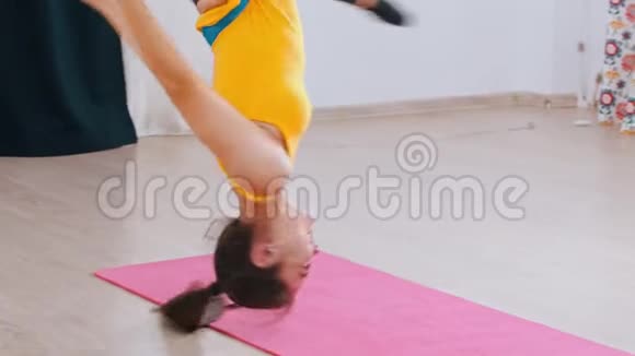 空中瑜伽微笑的女人倒挂在吊床上练习瑜伽视频的预览图