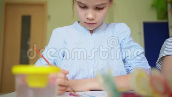 小女孩用画笔和颜料画画视频的预览图