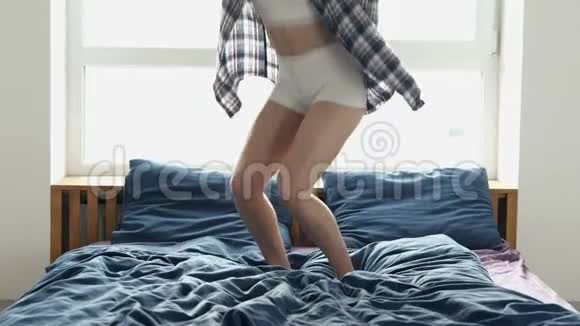 隔离期间年轻女子呆在家里穿着睡衣或家居服的身材苗条的女孩躺在床上俯视视频的预览图