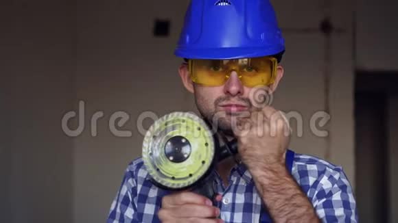 一个严肃的男建筑工用电动建筑工具的肖像视频的预览图