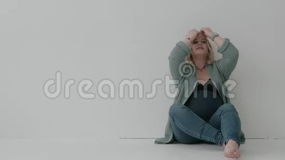 大龄孕妇坐在白色的墙上关于分娩的梦视频的预览图