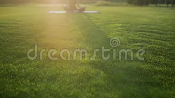 小女孩在公园草地上做瑜伽视频的预览图