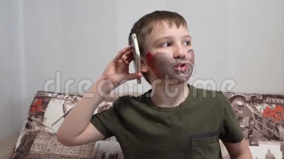 有脸漆的男孩在打电话打手势视频的预览图