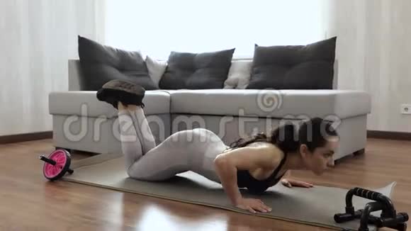 年轻女子在家锻炼身体健康苗条的模特在瑜伽垫上做主动俯卧撑视频的预览图