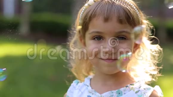 小女孩在公园里不同的眼睛颜色她玩肥皂泡视频的预览图