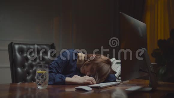 睡在夜班办公室桌子上的年轻女商人女人的睡眠被电话打断开始努力工作视频的预览图