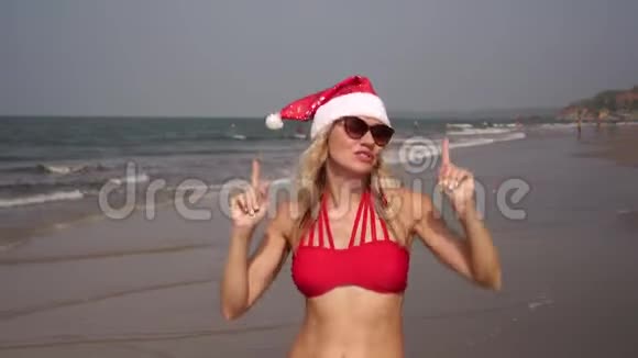 海滩上的圣诞节和新年美丽的女人在海边跳舞视频的预览图