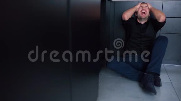 年轻的商人坐在地板上双手抱在头上他患有疾病或抑郁症头痛和强壮视频的预览图