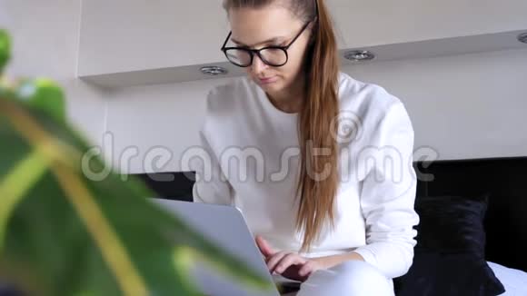 严肃的年轻女性在家上网看着屏幕上网在笔记本电脑上输入电子邮件注意力集中的女性视频的预览图