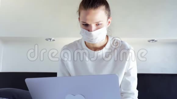 在家工作的笔记本电脑戴着面罩冠状病毒隔离视频的预览图