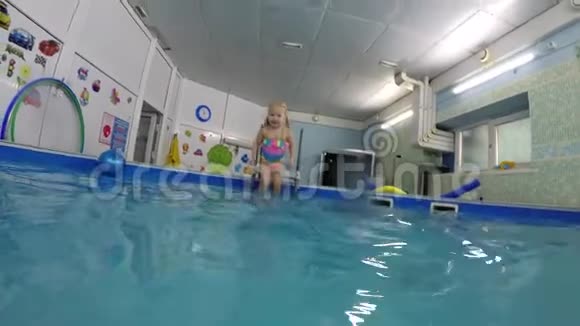 一个小女孩潜入游泳池在水下游泳视频的预览图