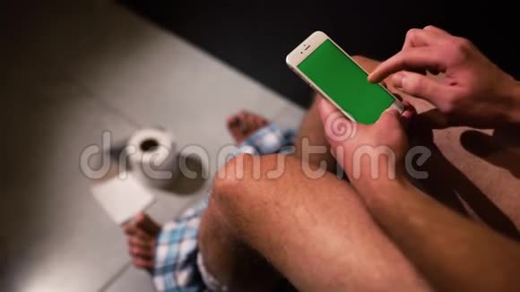 视频男子与裤子在脚打开手机在手和开始使用它向上向下和倾斜也放大视频的预览图