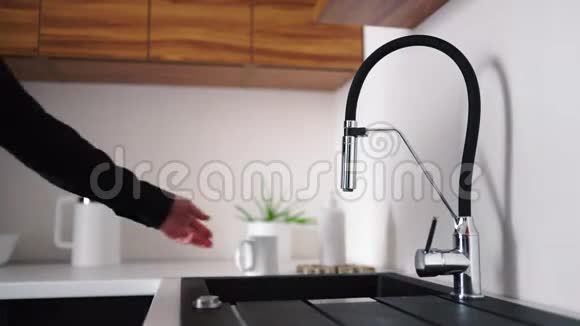 男子黑色衬衫的视频过程取白色杯子打开水龙头往里面倒些水让水流动视频的预览图