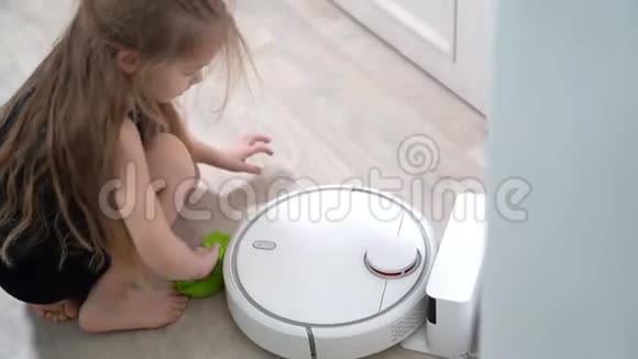 漂亮的金发女孩做清洁机器人吸尘器视频的预览图