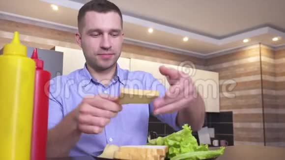 录制三明治制作过程的视频年轻人把生菜和奶酪放在上面视频的预览图