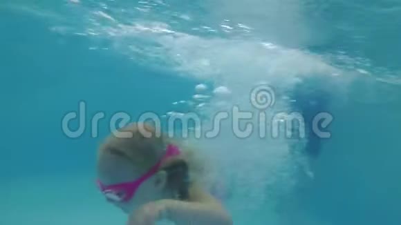 一个小孩子学会在游泳池里游泳一个女孩在水下游泳视频的预览图