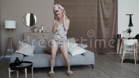穿着睡衣和拖鞋的漂亮女孩戴着无线耳机视频的预览图
