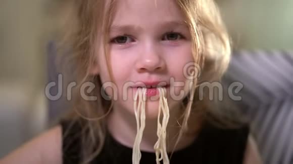 毛茸茸的小女孩吃着面条笑着特写镜头视频的预览图
