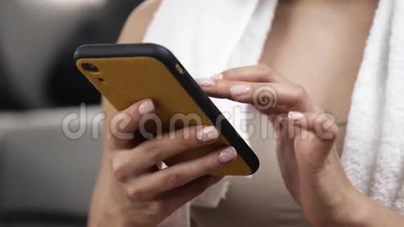 年轻女子在隔离期间在家锻炼关闭智能手机屏幕上的女性手指打字聊天视频的预览图