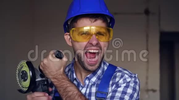 一个情绪愉快的建筑工人用电动工具的男性肖像视频的预览图