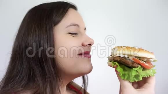 女人吃快餐汉堡包芝士汉堡的特写不健康的生活方式视频的预览图