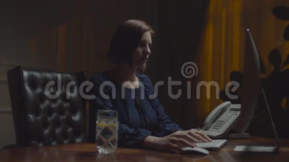 在夜间办公室工作的年轻女商人女人在键盘上打字和莱曼一起喝水工作女性视频的预览图