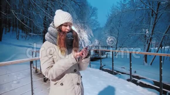 可爱的微笑女孩用手机在户外聊天冬天学生模特视频的预览图