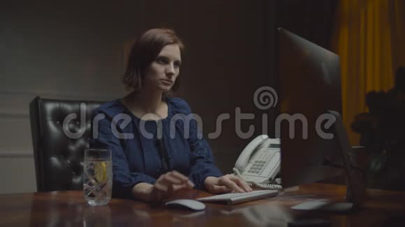在夜间办公室工作的年轻女商人女人在键盘上打字喝柠檬水工作女性视频的预览图