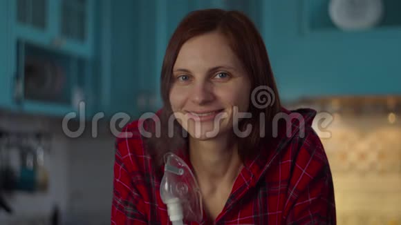 30多岁的年轻女性穿着红色衬衫在家里使用吸入器治疗流感或呼吸道病毒等疾病妇女视频的预览图