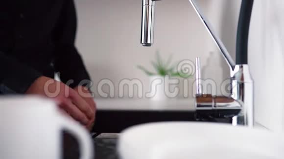 用海绵和手清洁白板的过程一个人站在水槽里用水打开水龙头结束之后视频的预览图
