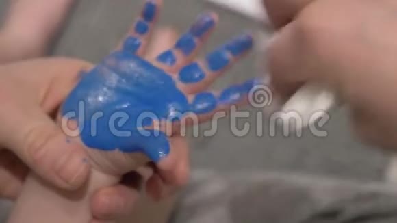 幼儿手掌与蓝色油漆视频的预览图