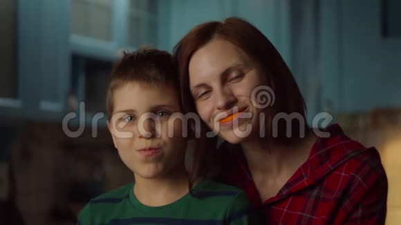 有趣的家庭在家里玩橘子皮微笑的女人和上学的孩子嘴里有橘子水果视频的预览图