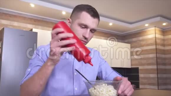 厨房里年轻人的视频在意大利面中加入一些番茄酱并与叉子混合准备美味可口的饭菜视频的预览图