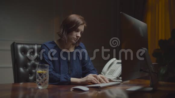 年轻疲惫的女商人在夜间办公室工作熟睡的女工在显示器前键盘打字视频的预览图