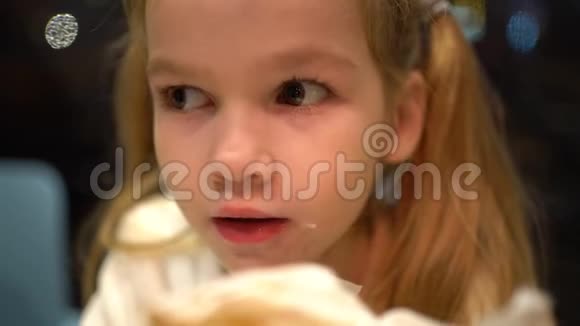 有尾巴的金发小女孩吃煎饼特写镜头视频的预览图