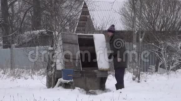 冬天的人在井里打水旋转一桶井水视频的预览图