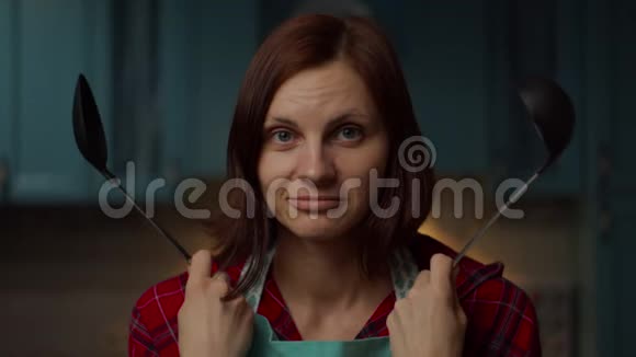困惑的30多岁的年轻女子手里拿着厨房用具犹豫地摇头女人不会做饭视频的预览图