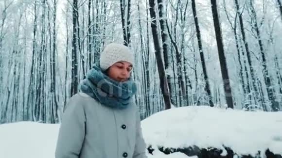 美丽的年轻旅游姑娘在雪林中徒步旅行的画像视频的预览图