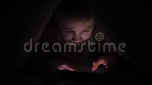 小女孩晚上在智能手机上玩游戏视频的预览图